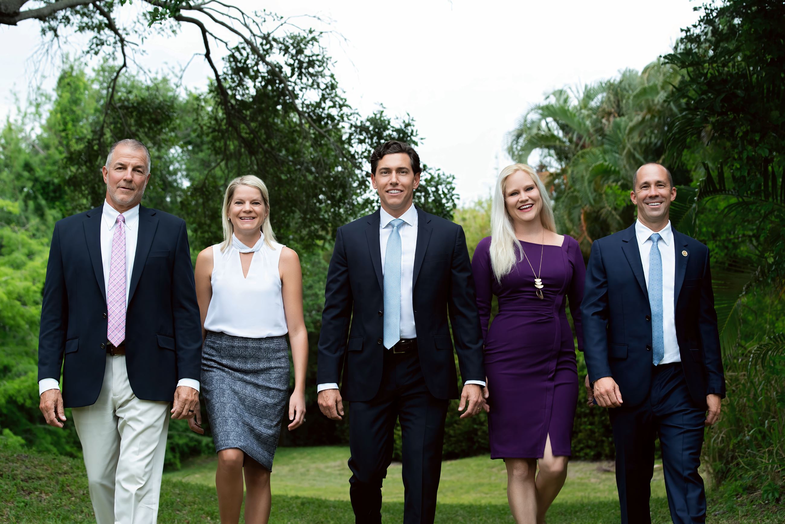 3 men and 2 ladies in professional attire walking together